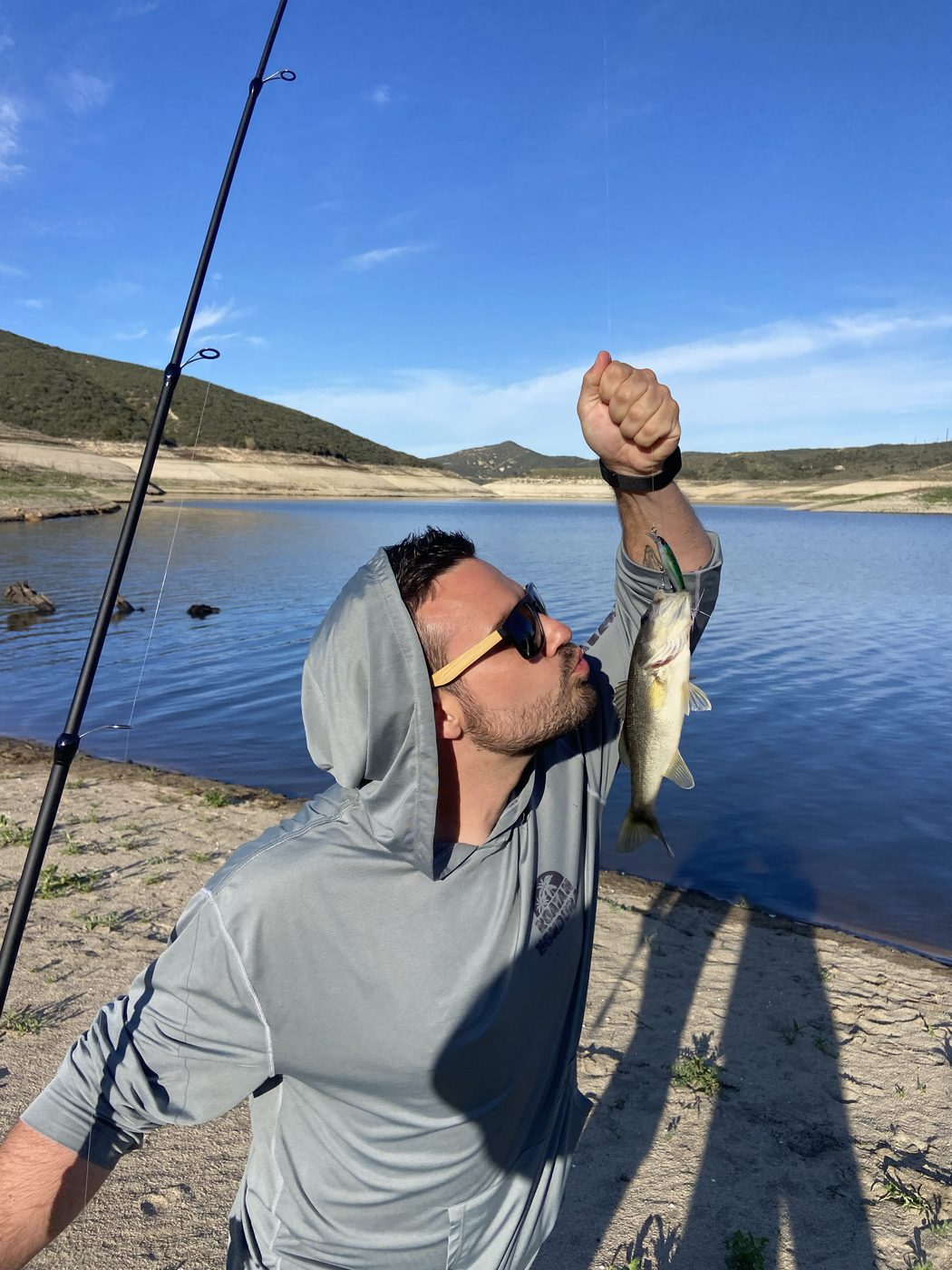 Trent kissing a largemouth bass at a lake